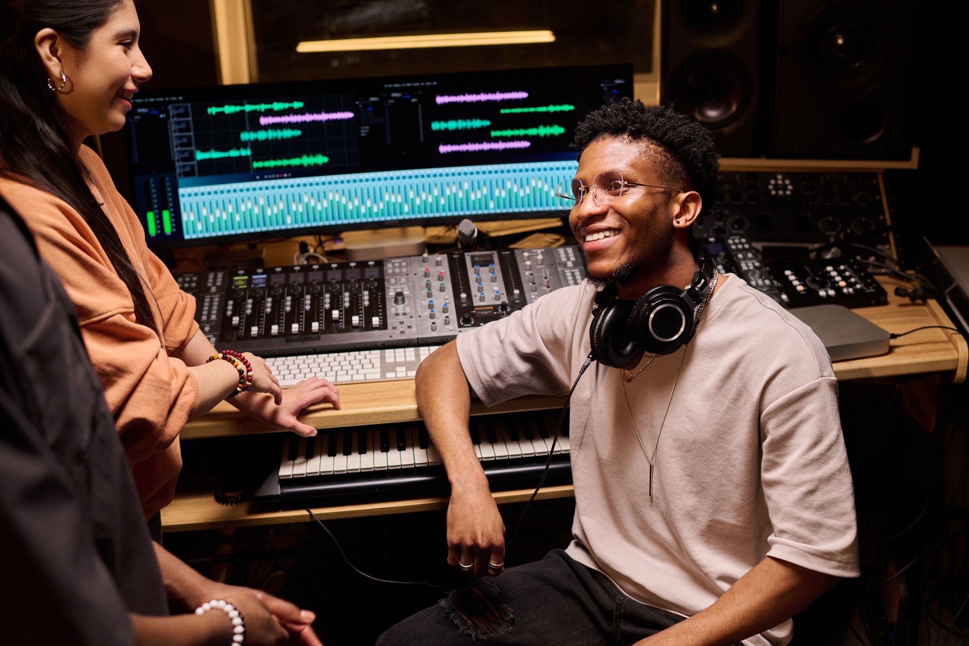 Young Black Man Smiling While Collaborating with Colleagues in Recording Studio