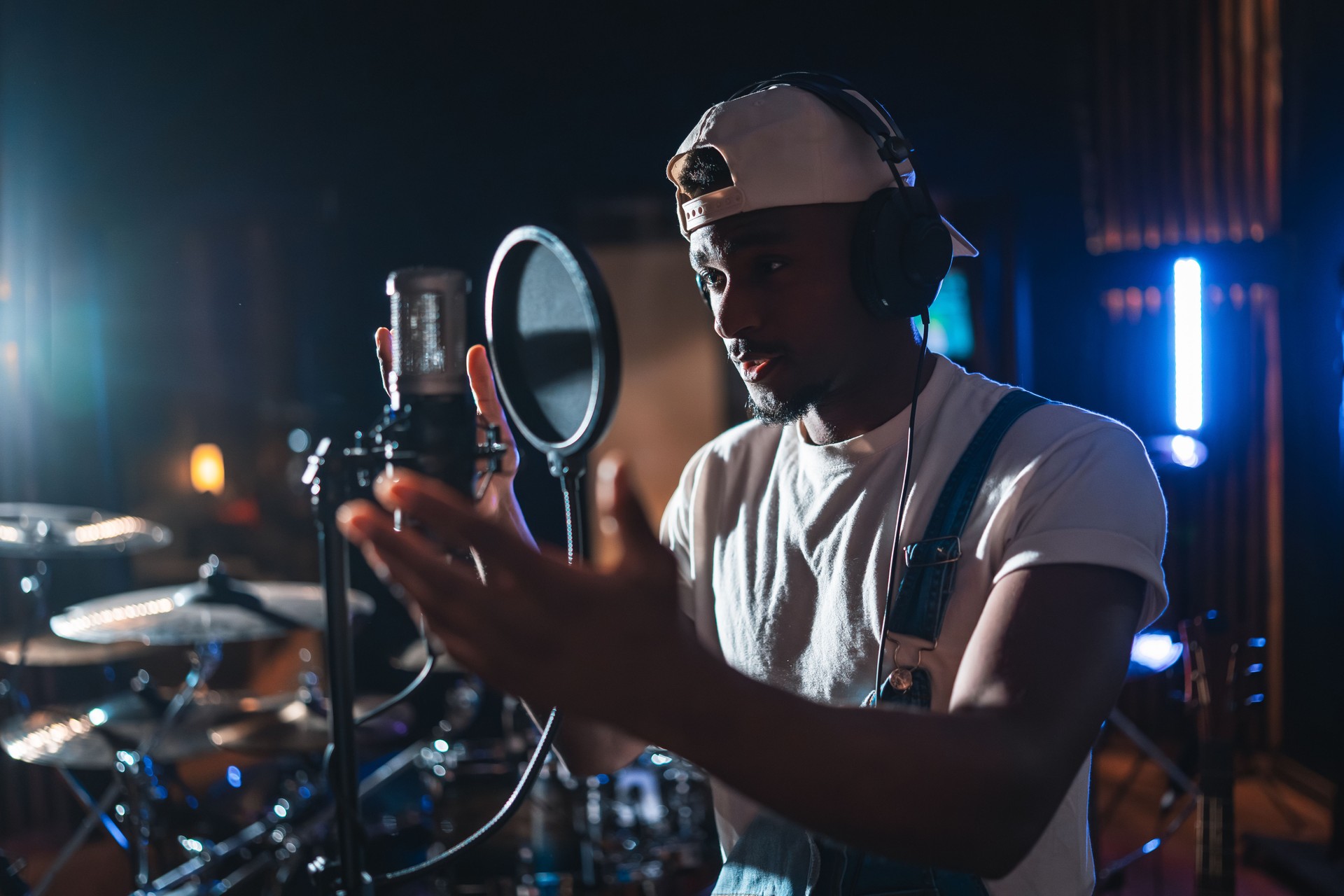 Young male singer recording music in professional studio